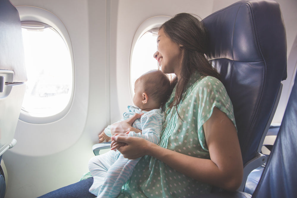 Postpartum mom flying on airplane with young baby.