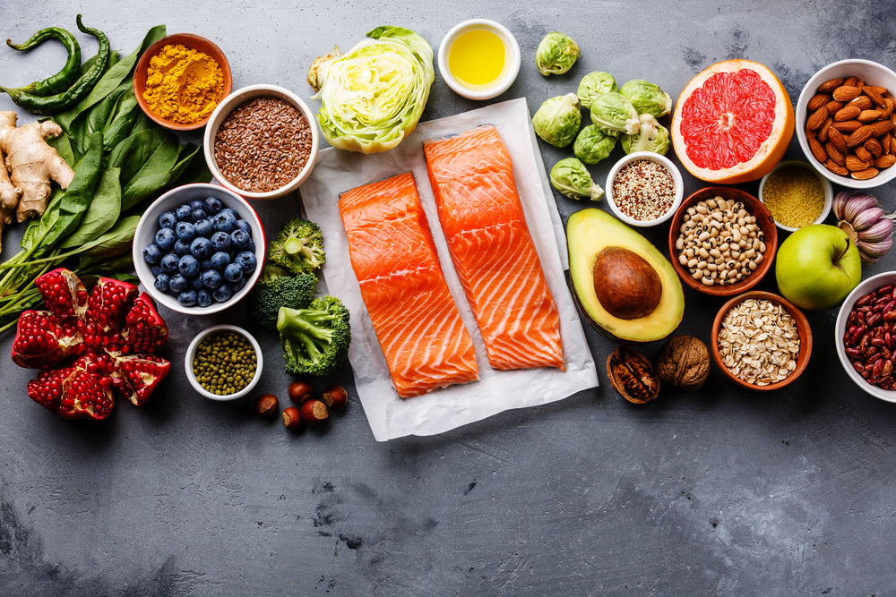 A spread of superfoods for postpartum on a table. Containing salmon, avocado, oatmeal, and yogurt.